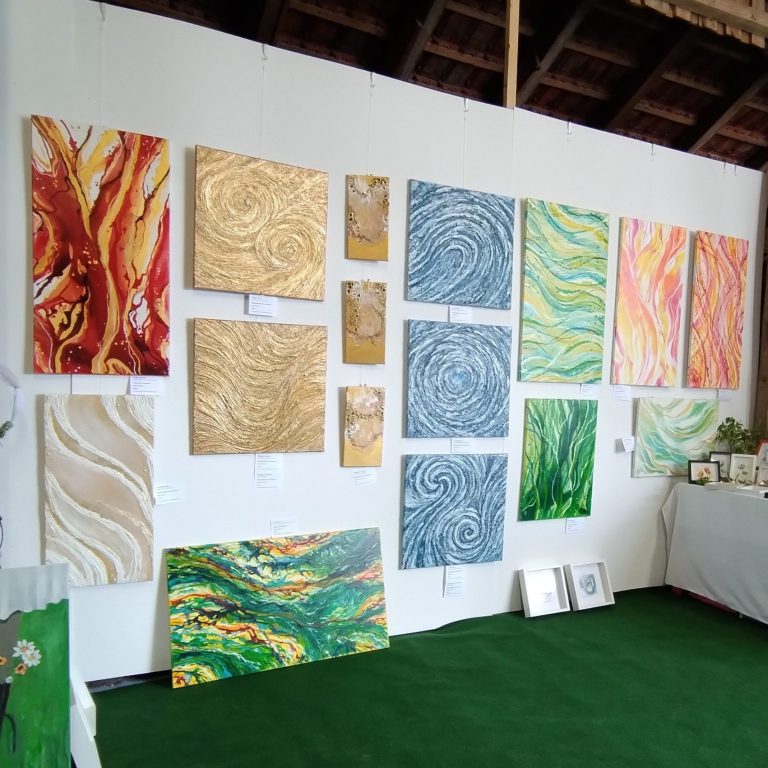 Moderne Lounge mit hohen Barhockern, Teppichboden und farbenfrohen Kunstwerken an der Wand.